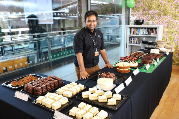 Dr Rahul Mandal with a display of cakes for the Nuclear AMRC's Macmillan coffee morning